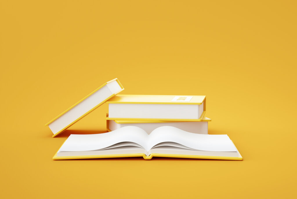 Stack of hardcover books with yellow covers and an open book, showcasing high-quality book printing and binding services.